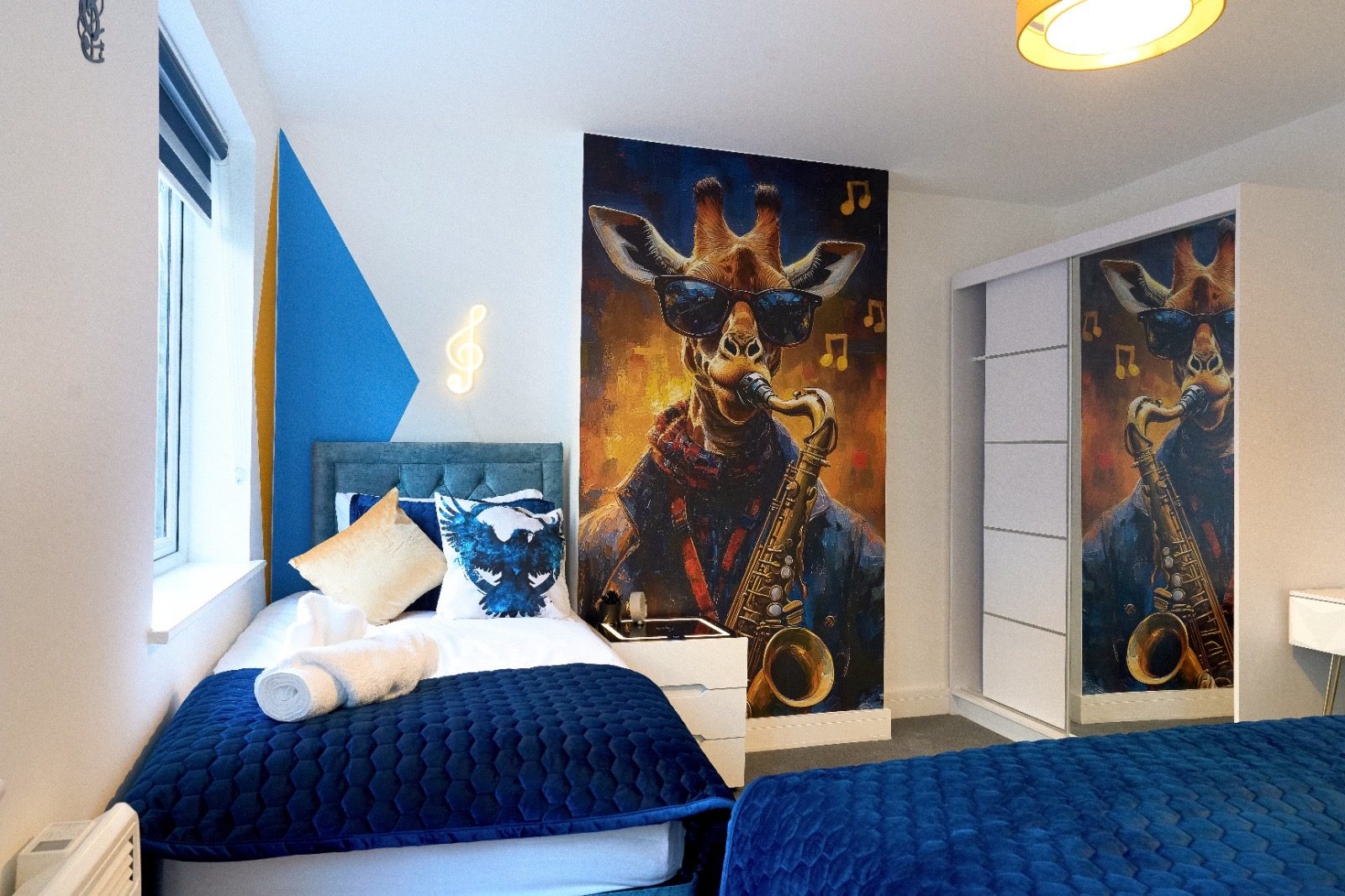 Twin beds with a saxophone giraffe mural