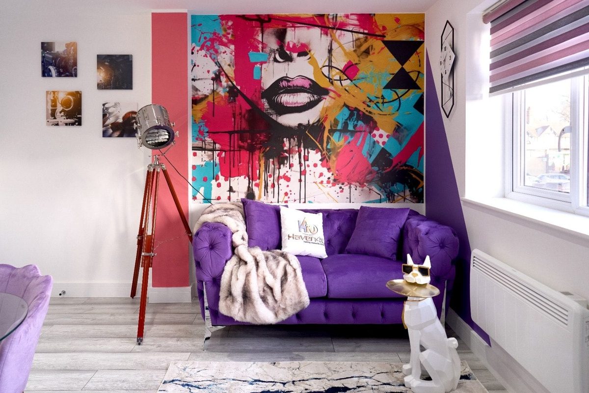 Purple velvet chesterfield sofa in front of a graffiti mural
